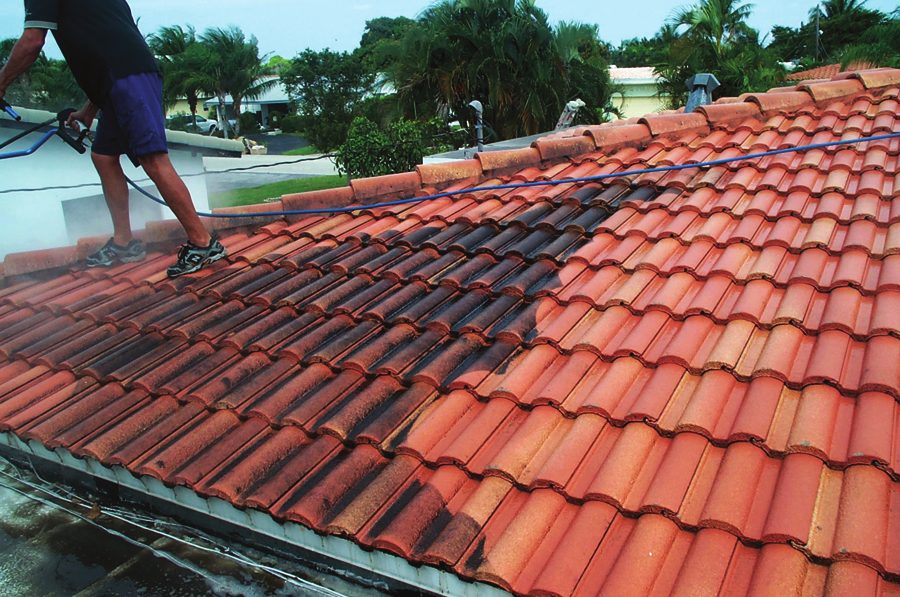 Clay tile roof half cleaned with SIMIX Cleaner, showing the clean section beside the algae-stained section